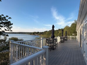 A wooden deck with outdoor seating and a view of a lake. - New listing, gorgeous home w/salt water pool in Sandwich, 
10 min from bridge!! (Sandwich)
