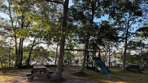 A park with picnic tables, a playground with a slide, and trees. - New listing, gorgeous home w/salt water pool in Sandwich, 
10 min from bridge!! (Sandwich)