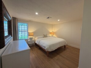 A bedroom with a bed, bedside lamps, a window with blinds, and a white dresser. - New listing, gorgeous home w/salt water pool in Sandwich, 
10 min from bridge!! (Sandwich)