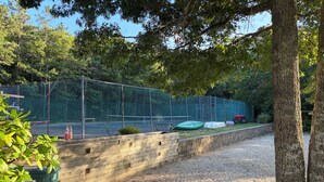 A fenced outdoor area with a gravel path, a wooden wall, and trees. - New listing, gorgeous home w/salt water pool in Sandwich, 
10 min from bridge!! (Sandwich)