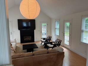A living room with a fireplace, a sofa, a coffee table, and a TV. - New listing, gorgeous home w/salt water pool in Sandwich, 
10 min from bridge!! (Sandwich)