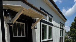 A house with a porch, a welcome mat, and outdoor chairs. - Modern New Cabin in East TN. Near Cherokee Lake and 1 hr to Pigeon Forge (Bean Station)