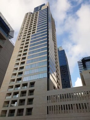 A tall building with a modern design, featuring multiple floors and a prominent facade. - 22nd Fl Damac Tower - 1 BedRoom Apt with Balcony (Amman)