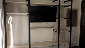 Et soveværelse med køjeseng, garderobe, spejl og et vindue.