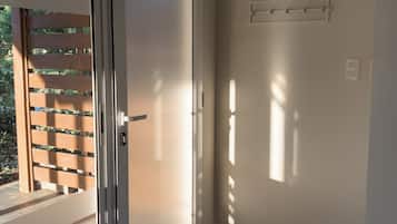 Ein Zimmer mit einer Schiebetür und Zugang zu einem Außenbereich mit Holzzaun und Grünpflanzen.