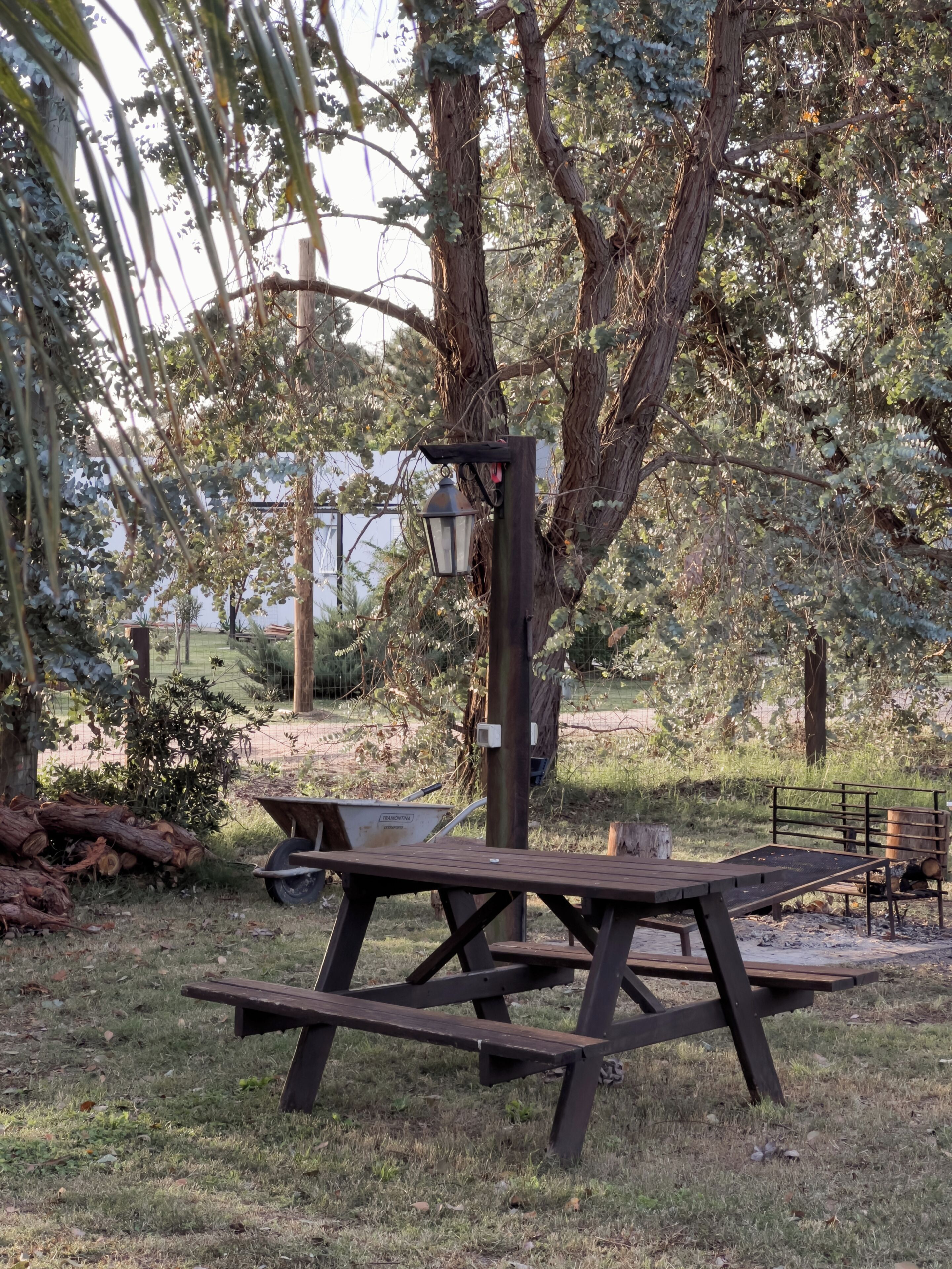 A picnic table with a lamp post in a park.