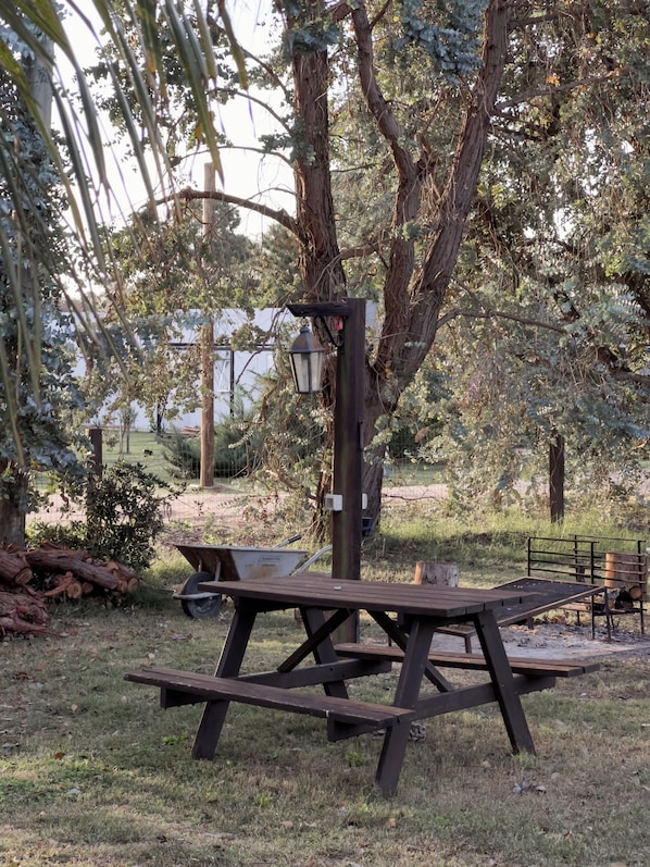 A picnic table with a lamp post in a park.
