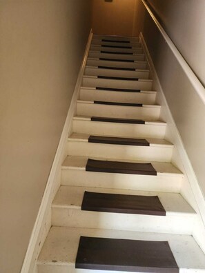 Eine Treppe mit weißen Stufen und dunklen Trittflächen, die nach oben führt.