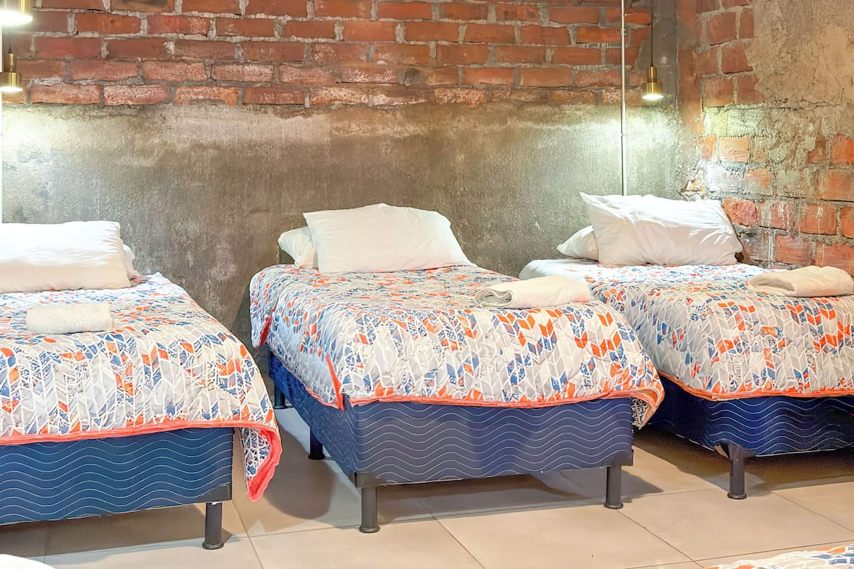 Habitación, varias camas | Edredón, tabla de planchar con plancha, wifi gratis y ropa de cama 