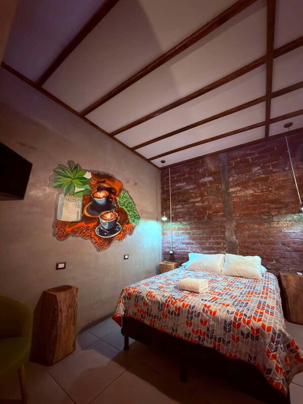 Un dormitorio con una cama, una pared de ladrillo y un mural.