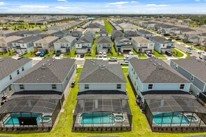 Ett bostadsområde med flera tvåvåningshus, en huvudgata och en swimmingpool med ett överbyggt soldäck.