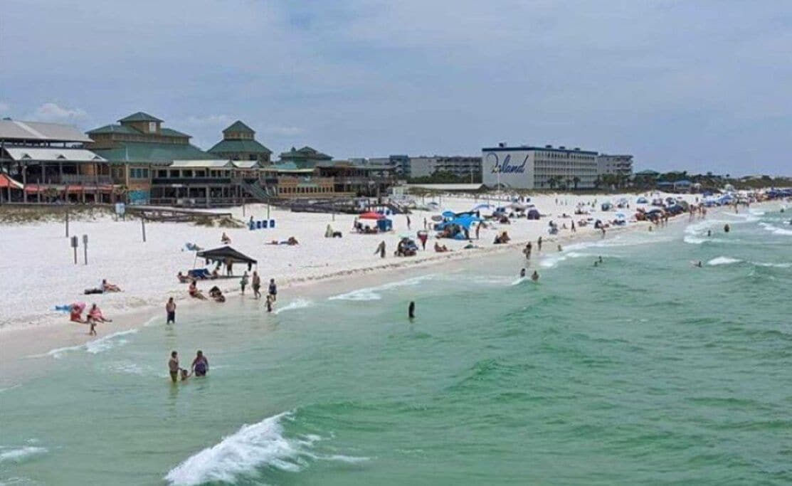 A beach with buildings, including a hotel named 'Island.'
