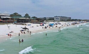 Ein Strand mit Gebäuden, darunter ein Hotel namens 'Island'.
