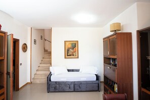 Ein Schlafzimmer mit einem Bett, einer Treppe, einem Gemälde und einem Bücherregal.