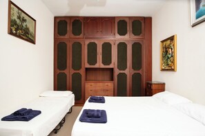 A hotel room with two beds, a wooden wardrobe, and artwork on the walls. - VILLA 200 METERS FROM THE BEACH, GARDEN WITH GAZEBO AND BARBECUE AREA, PARKING SPACE INCLUDED (San Vito Lo Capo)
