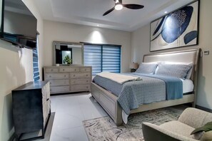 A bedroom with a bed, dresser, and a ceiling fan. - NEW~ Pool Access 3BR •Gated • Walk to the Beach (St. Ann Parish)