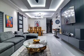 Uma sala de estar moderna com sofá, mesa de centro e área de jantar.