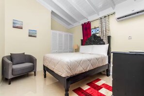A bedroom with a bed, a chair, a wardrobe, and a desk. - 3BR Oasis in Drax hall ~ Pool~ Gym ~ Gated ~Tennis (Saint Ann's Bay)