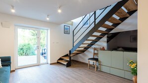 Ein modernes Interieur mit Treppe, Essbereich und Blick durch eine Glastür.