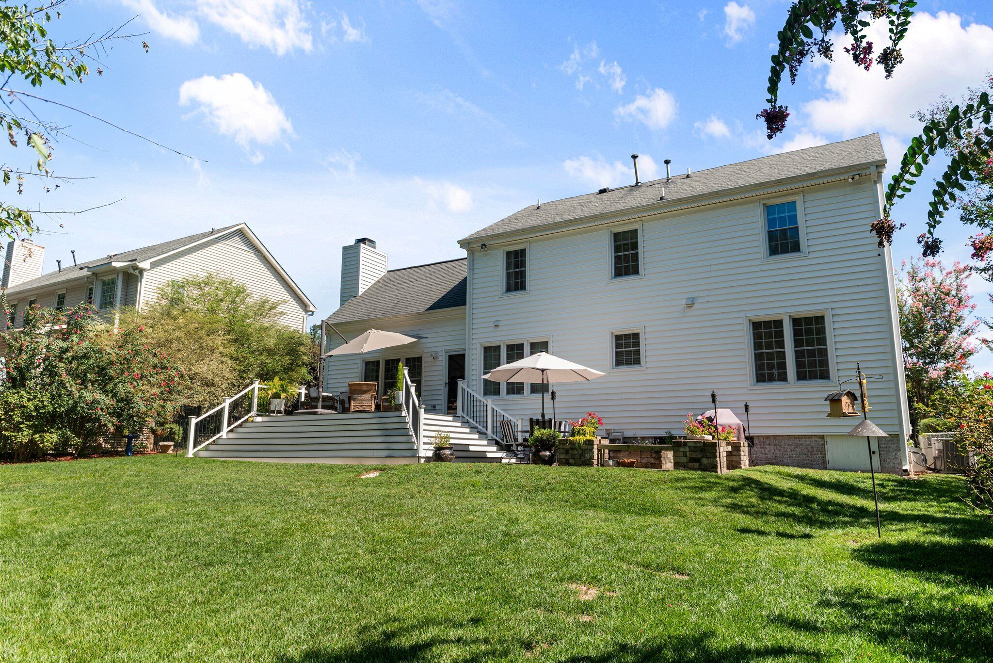 A two-story house with a front porch, a staircase, and a well-maintained lawn.