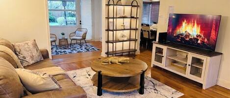 A living room with a sofa, coffee table, TV, and a bookshelf.