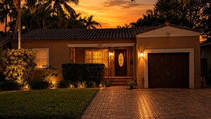 A residential house with a brick driveway, a garage, and a well-maintained lawn. - Rio Vista Gem , Walk to Las Olas , 6 Min to Beach ,Private Backyard 2 Bedrooms (Fort Lauderdale)
