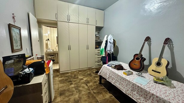 A room with a bed, two guitars, a desk with a computer, and a wardrobe. - Beach house with pool in Porto das Dunas, 7 bedrooms + garage for 6 cars. (Aquiraz)