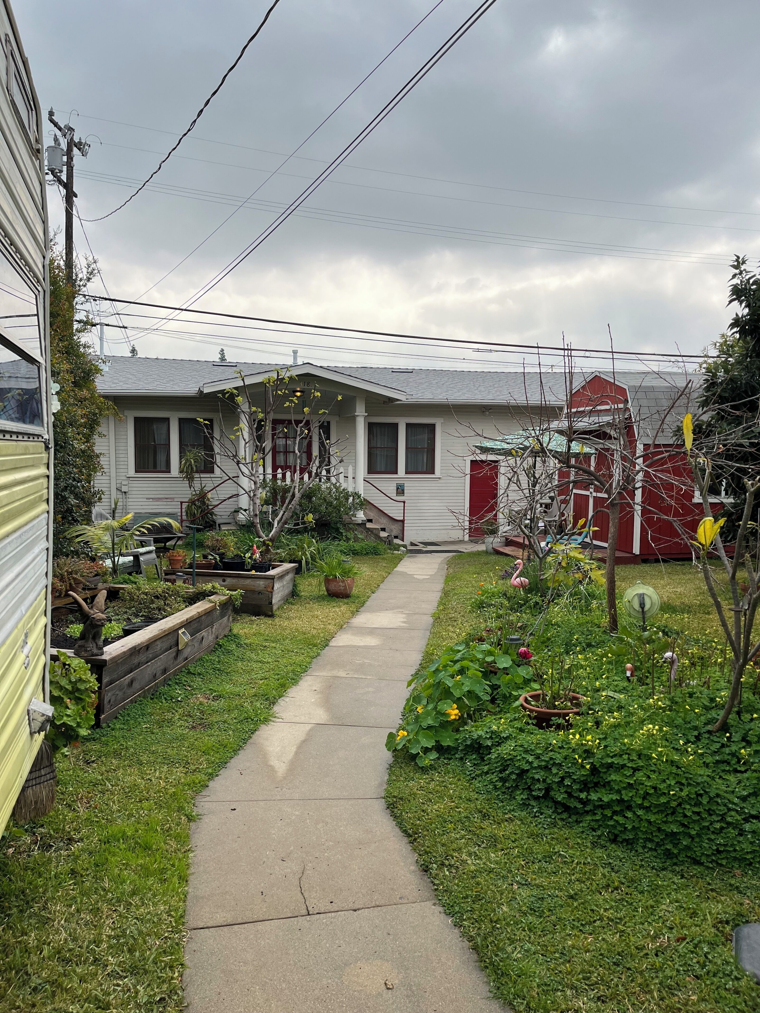 Il s’agit d’une propriété résidentielle dotée d’un jardin devant la maison, d’un chemin menant à l’entrée et, au fond, d’une grange rouge.