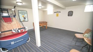 Une pièce équipée d’un baby-foot, d’un jeu de fléchettes et d’un panier de basket.