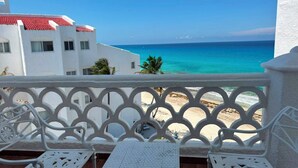 A balcony with white wrought iron railings, a small white table, and two white chairs. - Cancun Plaza Caribbean Ocean View & Infinity Pool (Cancún)