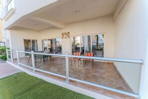 Un'area esterna coperta con patio, sedie e ringhiera.