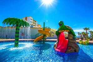Een zwembad met een waterglijbaan en een grote schildpadbeeld.