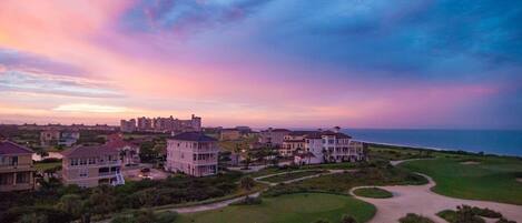 Un área residencial costera con casas, un campo de golf y vistas al océano.