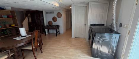 A spacious room with a dining area, a kitchen, and a hallway.
