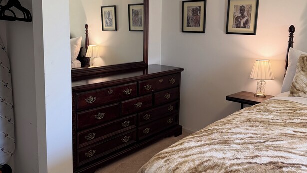 A bedroom with a bed, dresser, and a mirror. - Serene 2-bedroom private basement in charming Wentzville (Wentzville)
