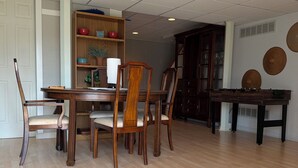A dining area with a wooden table and chairs, a bookshelf, and a wall with decorative plates. - Serene 2-bedroom private basement in charming Wentzville (Wentzville)