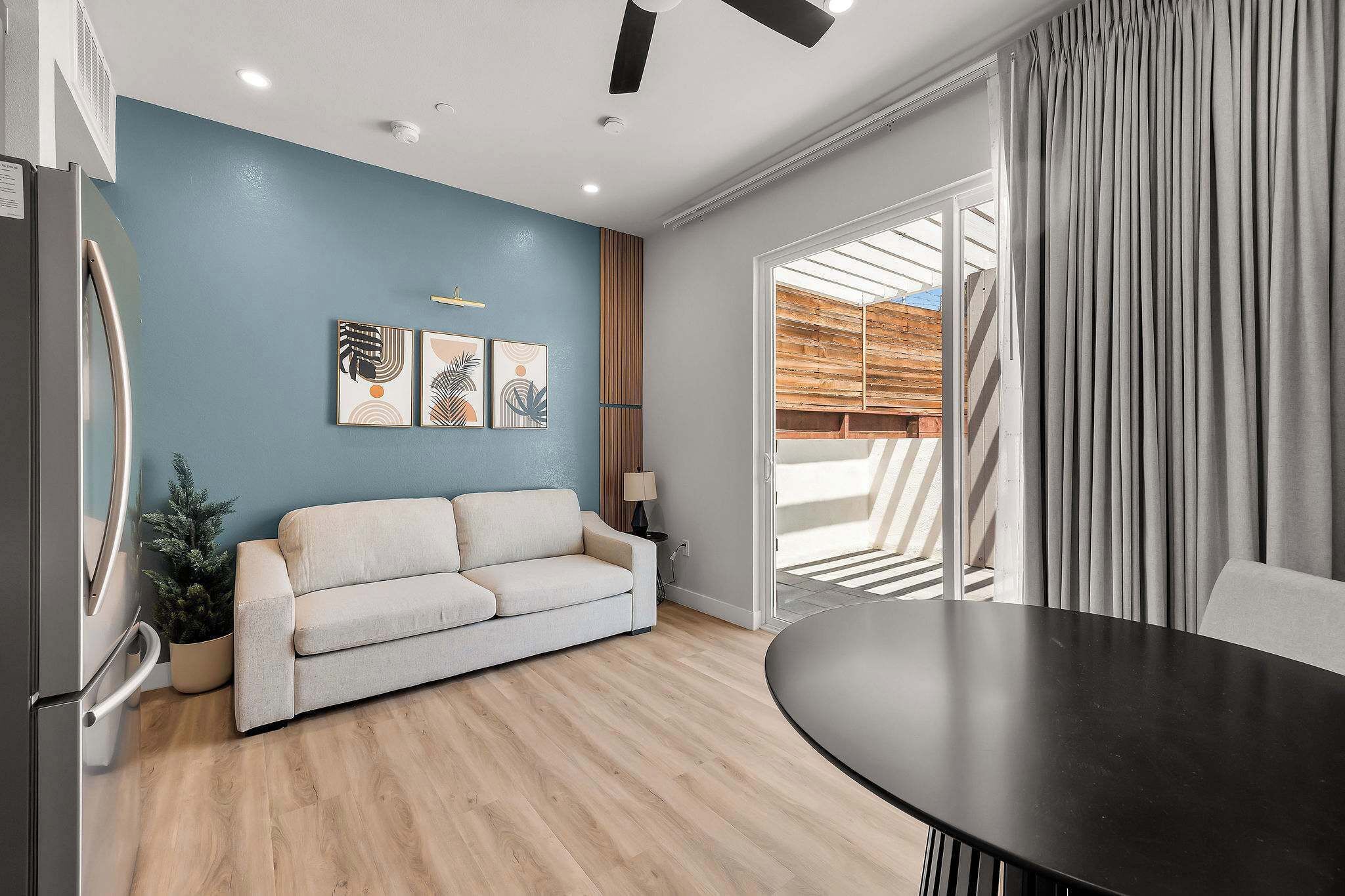 A modern living room with a sofa, a dining table, and artwork on the wall.