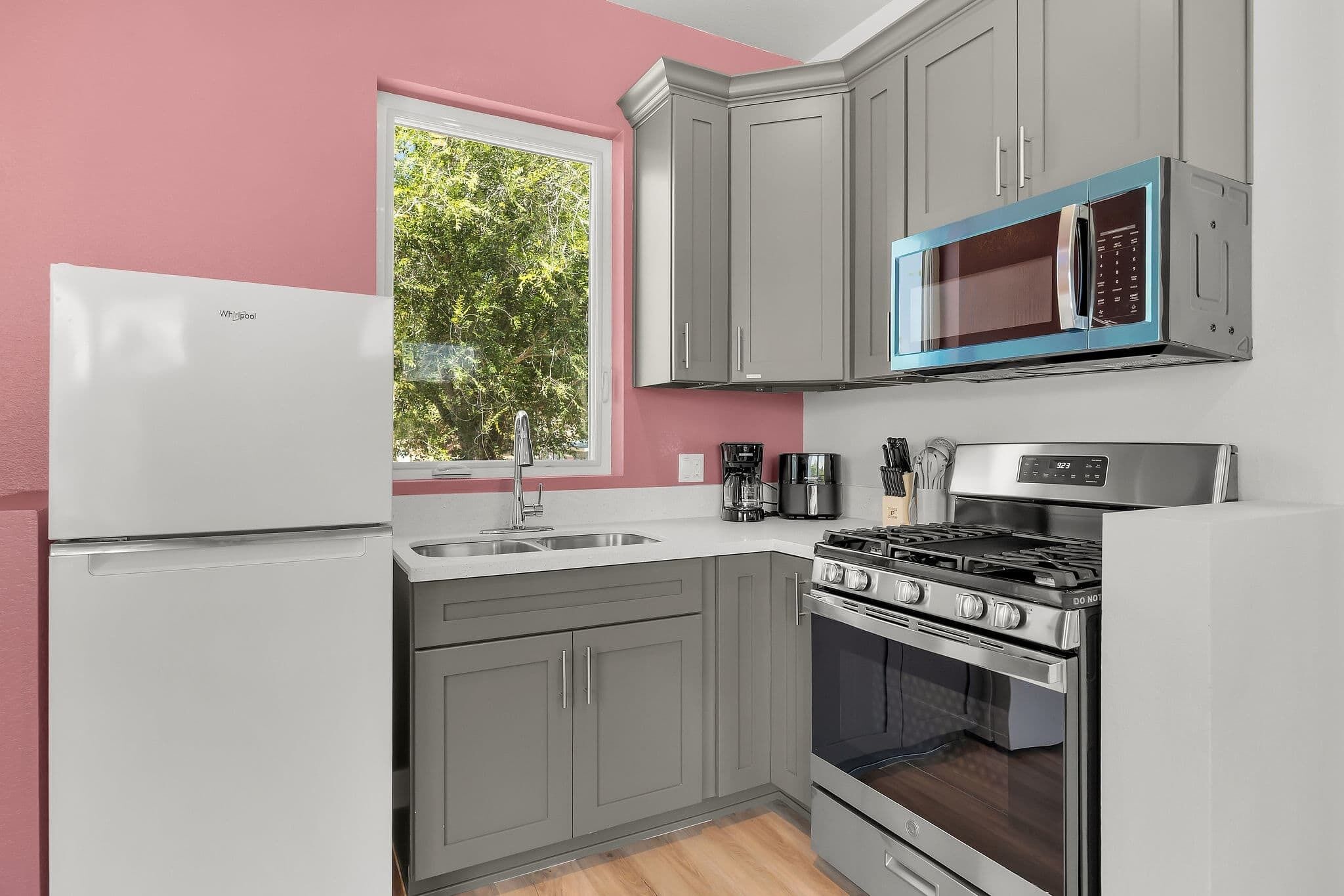 A kitchen with a refrigerator, stove, microwave, and sink.