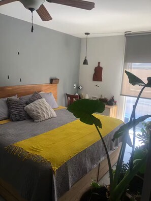A bedroom with a bed, a ceiling fan, a window, and a plant. - Departamento de Lujo Exclusivo, Vista y Literas. (tlajomulco de zuñiga)