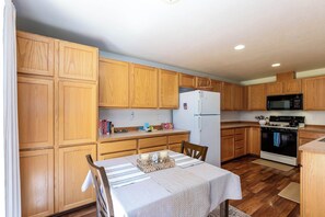 A kitchen with wooden cabinets, a refrigerator, an oven, and a microwave. - Near Old Mill: Dog-Friendly Bend House w/ BBQ and Fenced yard (Bend)