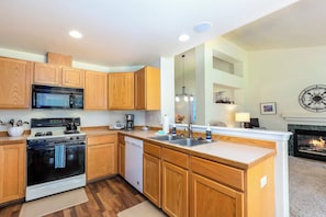 A modern kitchen with wooden cabinets, a built-in microwave, a stove, and a dishwasher. - Near Old Mill: Dog-Friendly Bend House w/ BBQ and Fenced yard (Bend)