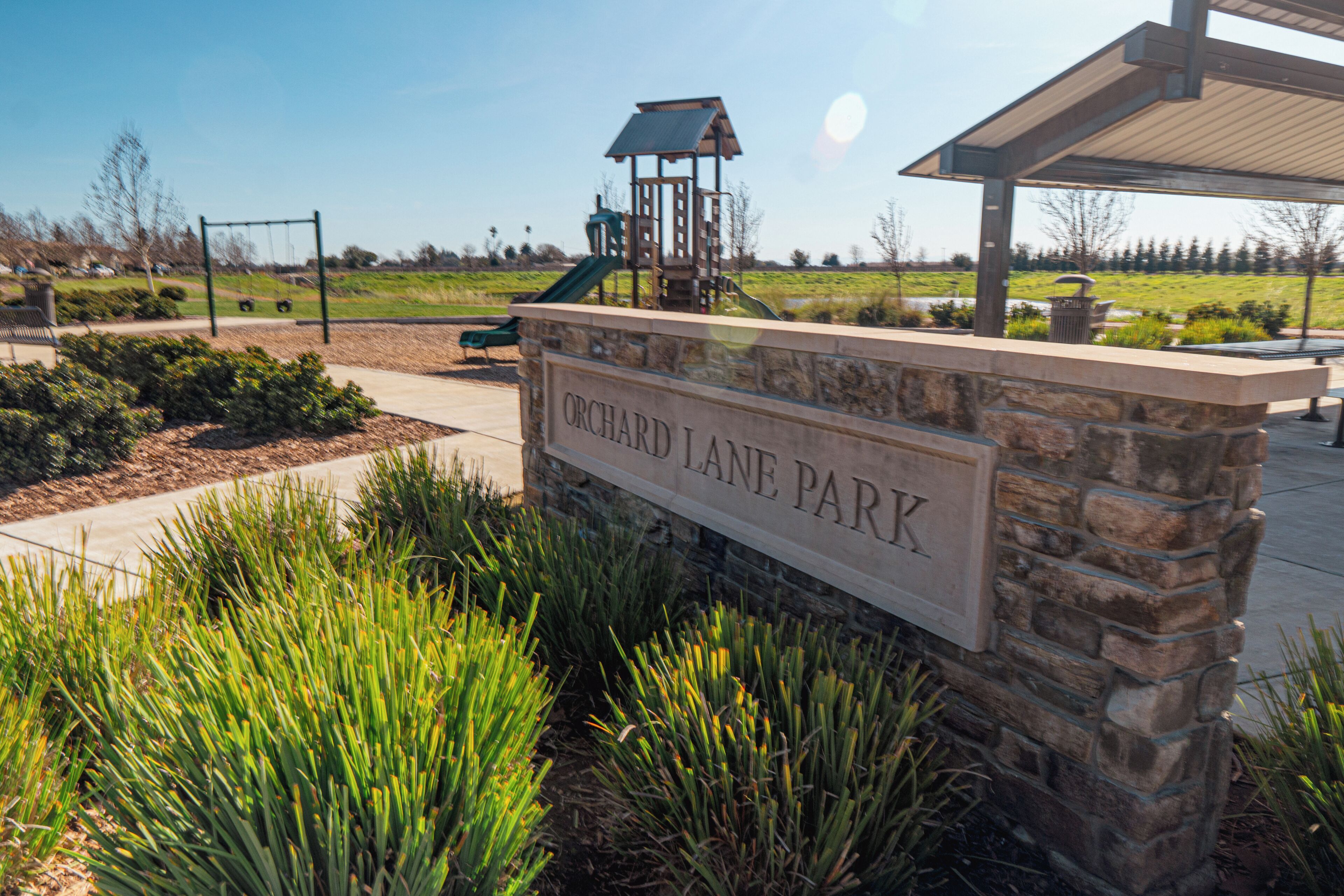 A park sign with 'ORCHARD LANE PARK' written on it.