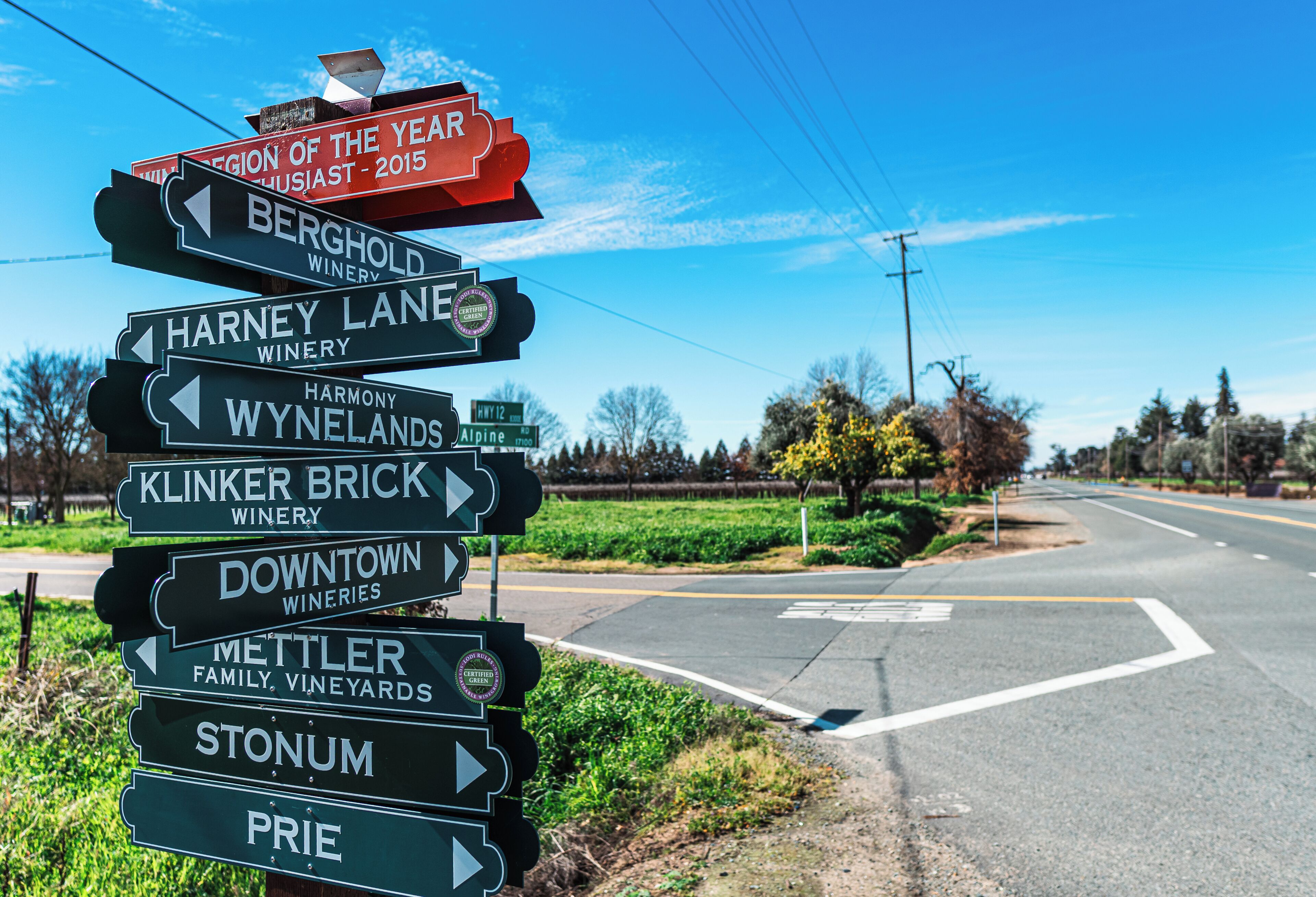A directional signpost with multiple arrows pointing to various wineries.