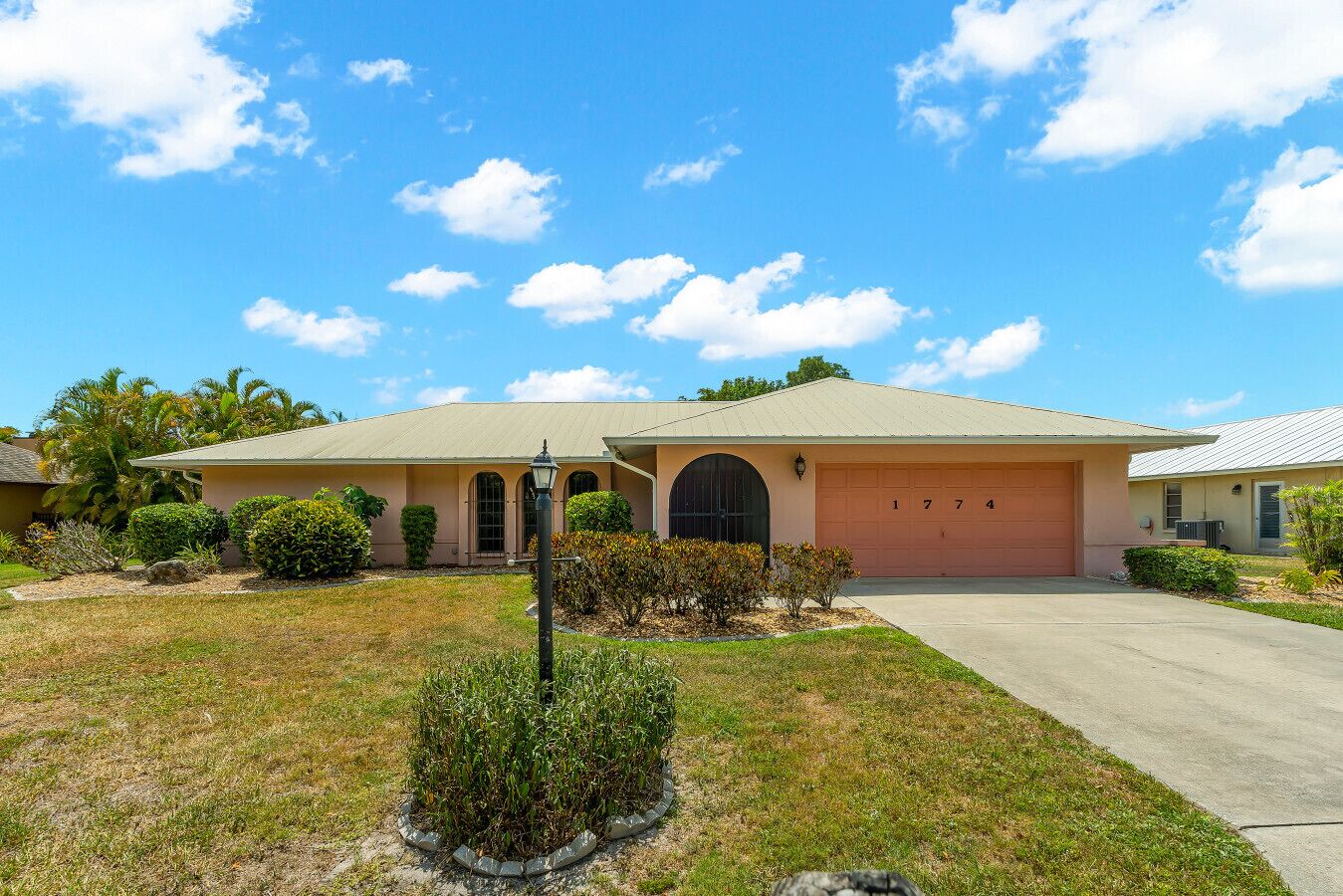 A single-story house with a garage, a well-maintained lawn, and a clear sky.
