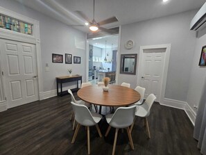 A dining area with a round table, six chairs, a ceiling fan, and a kitchen in the background. - Beautiful two minutes from Alamodome and all downtown fun (San Antonio)