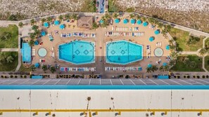 An aerial view of a hotel with two large swimming pools, sun loungers, and a parking lot. - Summit Unit 422 Gulf Front 1 Bedroom/Bunks (Panama City Beach)