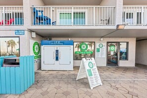 Ein Gebäude mit einem Automaten, der mit 'ICE 24-Stunden-Automat' beschriftet ist, und einem Schild für 'SOMMERMARKT'.