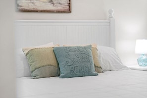 A bed with white bedding and two decorative pillows with text. - Summit Unit 422 Gulf Front 1 Bedroom/Bunks (Panama City Beach)