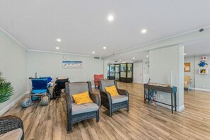 Eine großzügige Lobby mit Korbstühlen, einem blauen Rollstuhl und einem Empfangstresen.