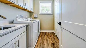 A laundry room with a washing machine, dryer, and sink. - Lakefront Escape | Private Pool + Dock Access (Mineral)